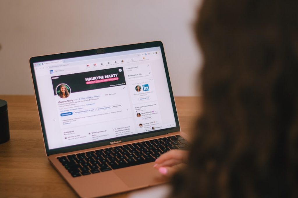 Person reviewing a professional profile on a laptop while evaluating a social selling CRM