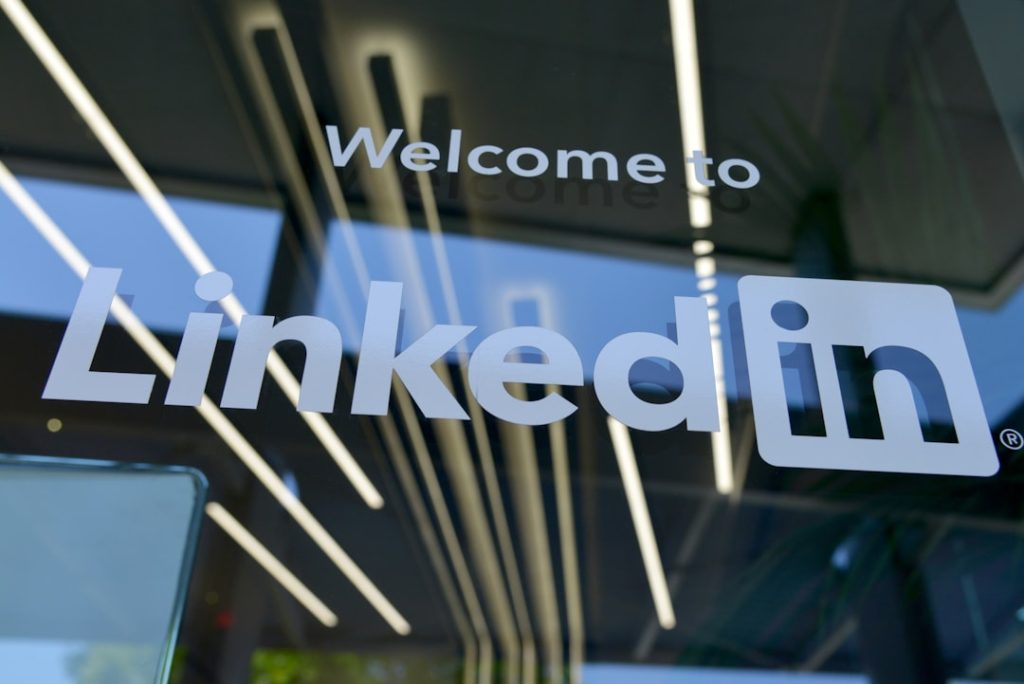 The LinkedIn logo and 'Welcome to LinkedIn' lettering etched on a glass office window, illustrating an article on connecting LinkedIn data to a CRM.