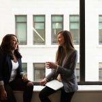 Two people in a warm business conversation, illustrating social selling tools that turn LinkedIn engagement into warm leads