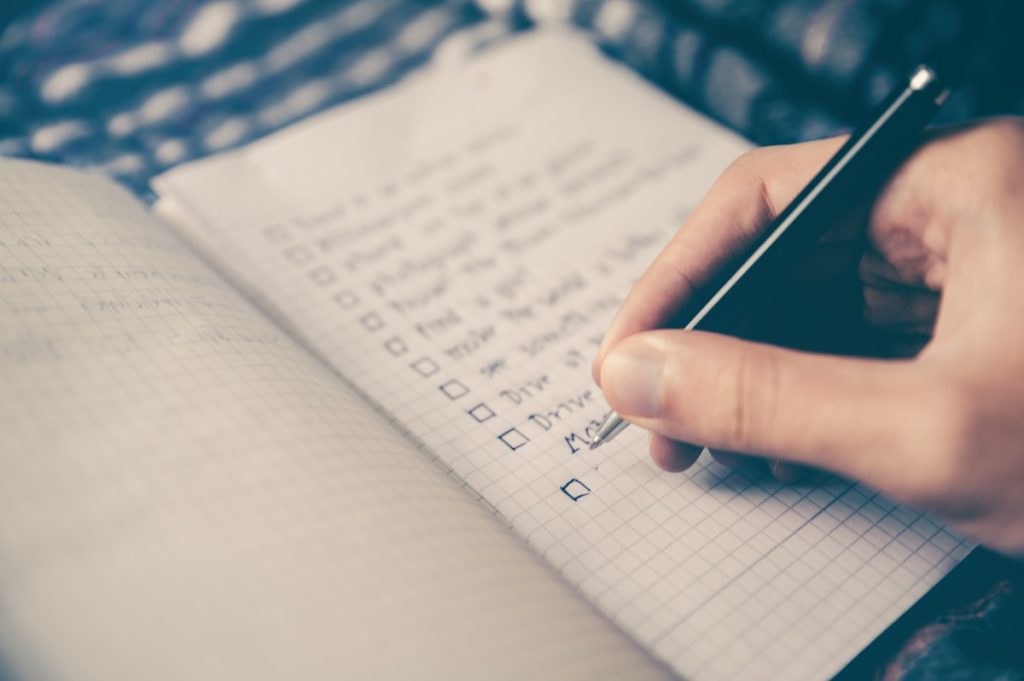 Person writing focused notes - warm outreach strategy for LinkedIn lead generation