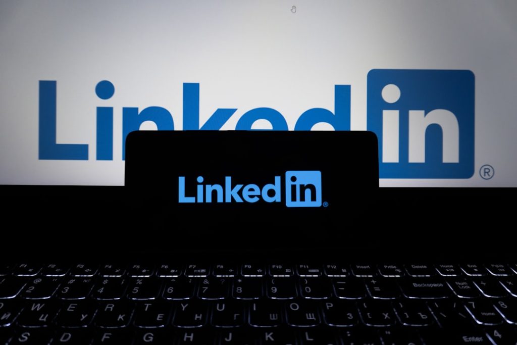 The LinkedIn app open on a phone beside a laptop, the setup used for a daily LinkedIn sales prospecting block.