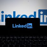 The LinkedIn app open on a phone beside a laptop, the setup used for a daily LinkedIn sales prospecting block.