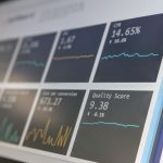 A wall-mounted monitor displaying live analytics charts and performance metrics, the kind of cadence reporting dashboard a sales engagement platform puts in front of a sales manager.